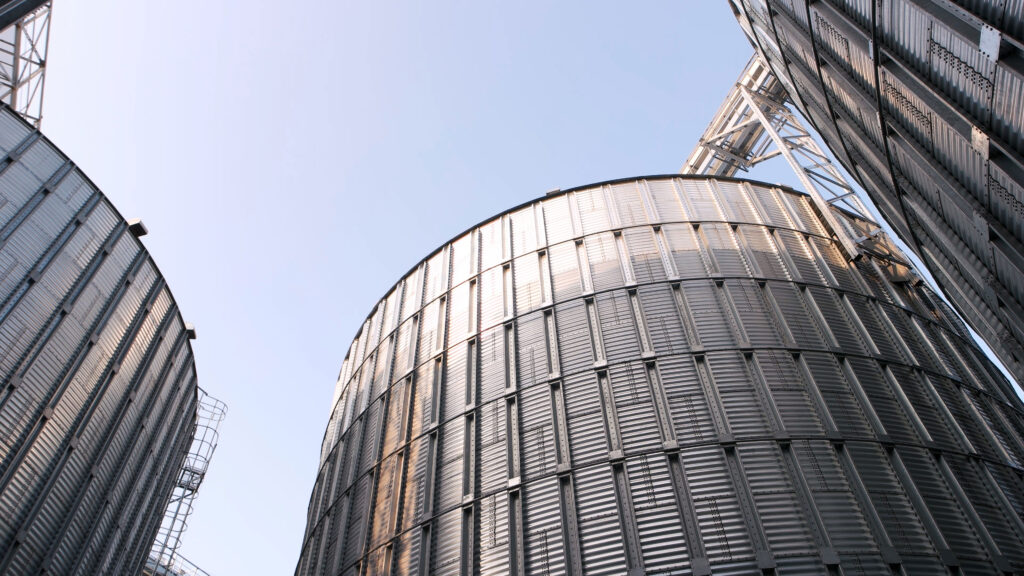 Low angle view of corrugated steel grain bins and agricultural storage silos